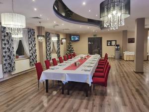 ein Konferenzraum mit einem langen Tisch und roten Stühlen in der Unterkunft Ośrodek Uzdrowiskowy Świerkowy Zdrój Medical Spa in Rymanów-Zdrój