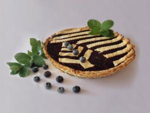 Ein Stück Kuchen mit Blaubeeren und Minze auf einem Teller in der Unterkunft Ośrodek Uzdrowiskowy Świerkowy Zdrój Medical Spa in Rymanów-Zdrój