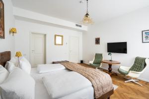 a white bedroom with a bed and a table and chairs at Nobel Boutique in Bucharest