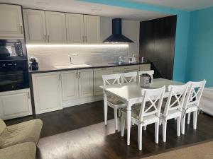 a kitchen with a white table and white chairs at Precioso apartamento en Espot in Espot