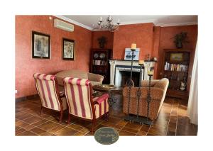 a living room with chairs and a table and a fireplace at DON JULIO in Perales del Puerto