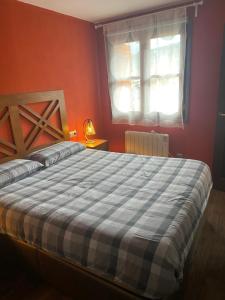 1 dormitorio con 1 cama con manta azul y blanca en Precioso apartamento en Espot en Espot