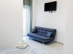 a blue couch in a room with a tv at In Centro rooms in Castellabate