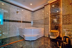 ein Bad mit einer großen Badewanne in einem Zimmer in der Unterkunft Cabir Deluxe Hotel Sapanca in Sapanca