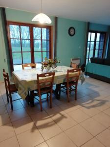 un comedor con mesa, sillas, mesa y sillón en LA VALLEE MARIAUX, en Bossus-lès-Rumigny