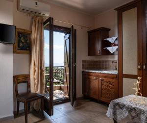 a kitchen with a door open to a balcony at Chorostasi Guest House in Parthenonas +50 photos