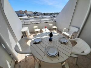 a table and chairs on a balcony with a view at Village Naturiste - Port Ambonne in Cap d'Agde