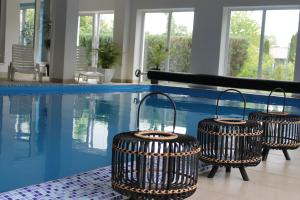 a swimming pool with three wicker baskets next to it at Penzión Hellene in Piešťany