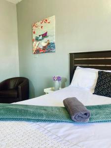 a bedroom with a bed with a towel on it at The Eden Lodge Verulam in Verulam