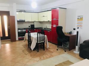 a kitchen with red cabinets and a table and chairs at Old Train Station Tirana in Tirana