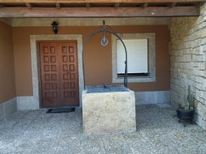 una puerta delantera de una casa con un mostrador de piedra al lado de una puerta en Casa do Carballal, en Puentecesures