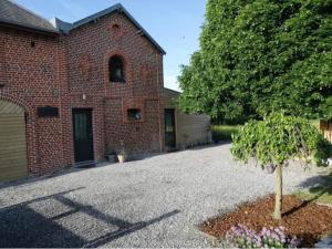 une maison en briques avec un arbre dans l'allée dans l'établissement LE TILLEUL DE FERON, à Féron