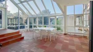 a conservatory with a table and chairs in a room with windows at RAJ Living - City Apartments with 2 , 3 and 6 Rooms - 15 Min to Messe DUS and Old Town DUS in Düsseldorf