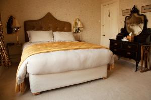 a bedroom with a large bed and a dresser with a mirror at St Katharine's House in Milford Haven +7 photos