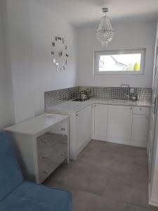 a kitchen with a sink and a clock on the wall at Poprzeczna 7 in Sarbinowo