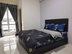 a bedroom with a bed with a blue comforter and a window at BC Homestay @ Emerald Avenue Apartment, Brinchang in Brinchang