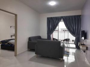 a living room with a couch and a bed and a window at BC Homestay @ Emerald Avenue Apartment, Brinchang in Brinchang