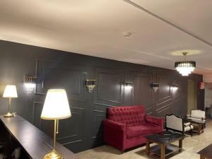 uma sala de estar com uma cadeira vermelha e uma mesa em Gulf Hotel Mumbai- The Boutique Hotel Colaba Mumbai em Mumbai