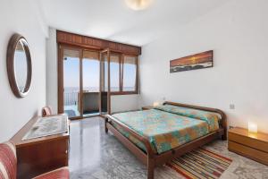 a bedroom with a bed and a large window at Appartamento stupenda vista mare in Bergeggi