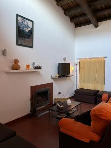 a living room with a couch and a fireplace at Apartamentos Rurales En Plena Sierra in La Calera