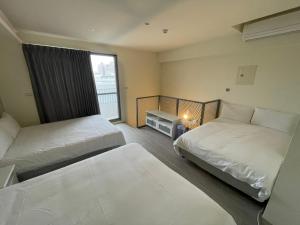 um quarto de hotel com duas camas e uma janela em 想想逢甲 Shine Residence em Taichung