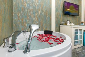 a bath tub filled with red petals in a bathroom at The Lea Hotel in Didim