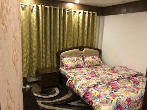 sypialnia z łóżkiem i zieloną zasłoną w obiekcie Kathmandu Sojourn-Your home away! (2BHK Apartelle) w Katmandu