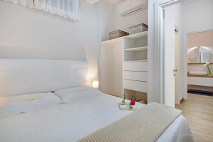 モネーリアにあるUn'oasi al Mareの白いベッドルーム(白いベッド1台、クローゼット付)
