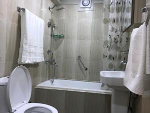 W łazience znajduje się toaleta, umywalka i prysznic. w obiekcie Kathmandu Sojourn-Your home away! (2BHK Apartelle) w Katmandu