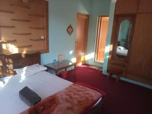 a hotel room with a bed and a mirror at Grand Inayat in Srinagar