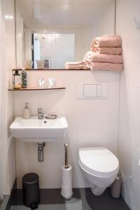 a white bathroom with a toilet and a sink at B&B Het Hart van Haarlem in Haarlem