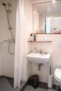 Baño blanco con lavabo y espejo en B&B Het Hart van Haarlem, en Haarlem