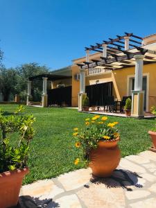 a house with a patio with flowers in a yard at L'Eremo Luxury Apartments in Roda