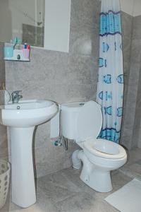 a bathroom with a toilet and a sink at Kiki's @ Palm Ridge-Vipingo in Kilifi