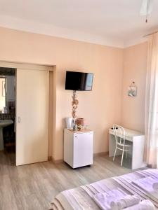 Schlafzimmer mit einem Bett und einem Schreibtisch sowie einem TV an der Wand in der Unterkunft Casa Caterina Lake View Holidays in Peschiera del Garda