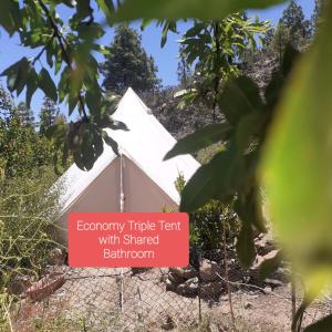 a tent with a sign that reads economy triple tent with shared bathroom at La finca del don Ganapati in San Bartolomé de Tirajana