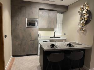 a kitchen with a sink and a counter with chairs at Voyage Residence فوياج ريسدينس للشقق المخدومة in Riyadh