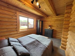 ein Schlafzimmer mit einem Bett in einer Blockhütte in der Unterkunft Blockhaus Waldsee 8 in Rieden