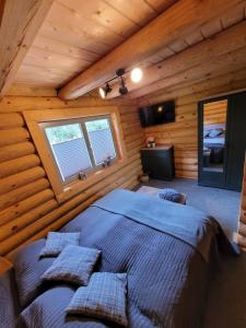 ein Schlafzimmer mit einem großen Bett in einem Blockhaus in der Unterkunft Blockhaus Waldsee 8 in Rieden
