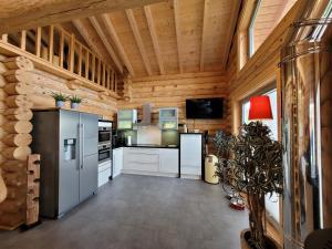 eine Küche mit weißen Geräten und einer Holzdecke in der Unterkunft Blockhaus Waldsee 8 in Rieden