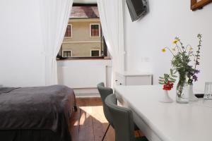 1 dormitorio con cama, mesa y ventana en Hotel im Stift Neuberg en Neuberg an der Mürz