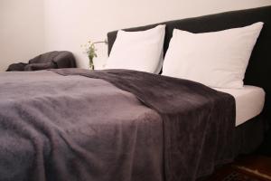 ein Bett mit einer braunen Decke und weißen Kissen in der Unterkunft Hotel im Stift Neuberg in Neuberg an der Mürz