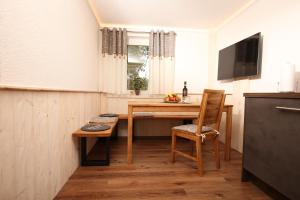 a kitchen with a table and a chair and a television at AlbLodges in Bitz