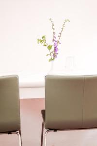 einen Tisch mit zwei Stühlen und eine Vase mit Blumen darauf in der Unterkunft Hotel im Stift Neuberg in Neuberg an der Mürz