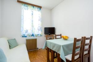 a dining room with a table and a tv at Apartment Jakovac in Njivice