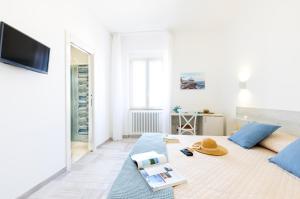 a white living room with a couch and a tv at B&B La Rosa dei Venti, panoramico nel cuore di Vieste Vista mare Centro storico in Vieste