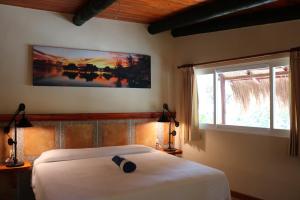 1 dormitorio con cama blanca y ventana en The Diving Lodge Downtown en Puerto Morelos