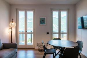 sala de estar con mesa y sillas en OLIVE TREE LAKE VIEW APARTMENT en Bellagio