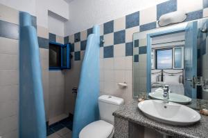 La salle de bains est pourvue d'un lavabo, de toilettes et d'un miroir. dans l'établissement Agnanti Beach Apartments, à Archangelos