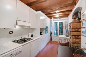 cocina con armarios blancos y fogones en Villa Sofia en Varenna